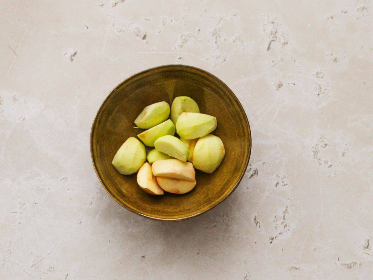 Peeled apples in a yellow bowl.