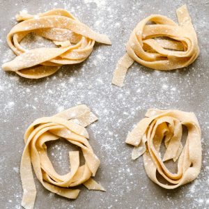Overhead shot of homemade pasta on a counter waiting to be cooked.