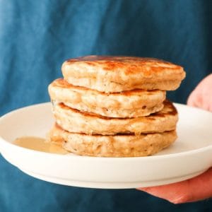 Close-up of oat pancakes without banana on a white plate with apples.
