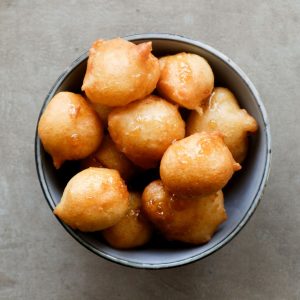 Overhead shot of loukoumade in a blue bowl.