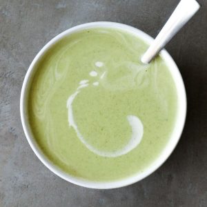 Vegan courgette soup in a bowl with a spoon.