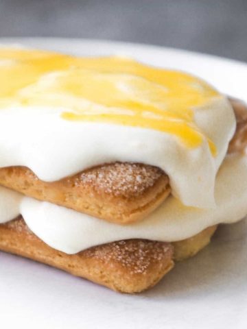 Individual lemon tiramisu with lemon curd on a white plate.