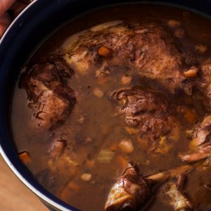 The best coq au vin recipe in a blue dutch oven.