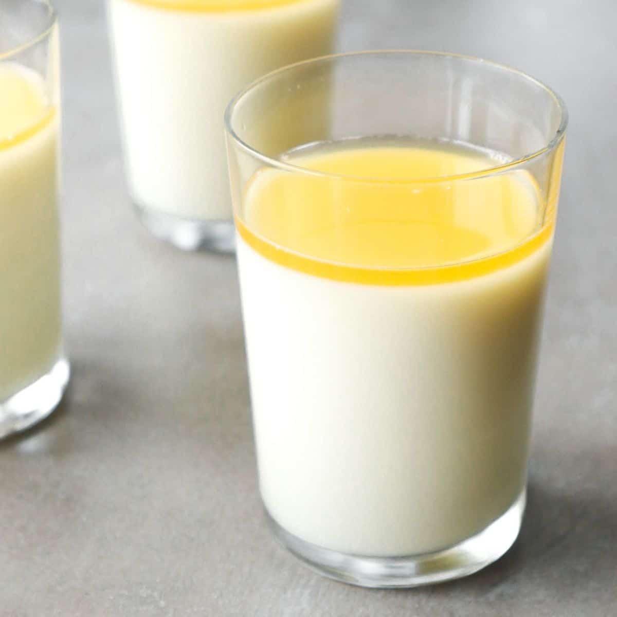 Lemon panna cotta with honey syrup in glasses.