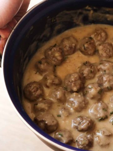 Kotbullar in gravy made in a blue pan.