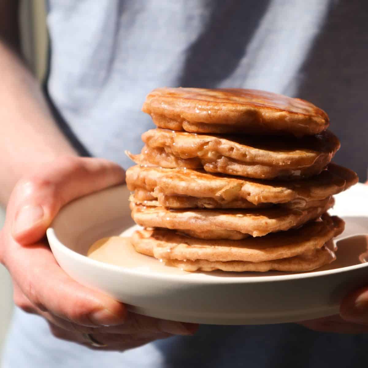 A stack of apple pancakes on a white plate.
