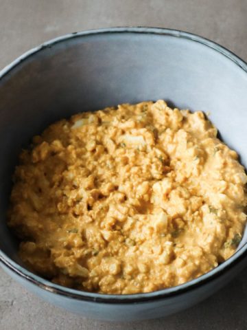 A close up of Greek yogurt egg salad in a bowl.