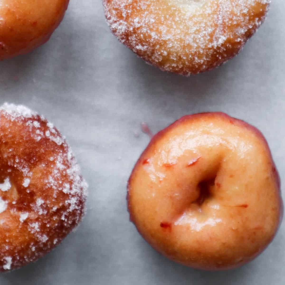 A close up of mini donuts with strawberry glaze.