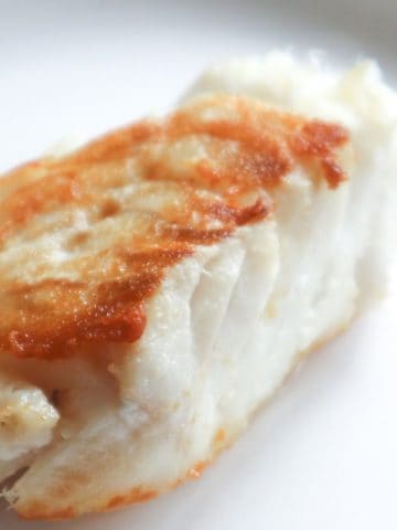 Perfectly pan-seared cod on a plate.
