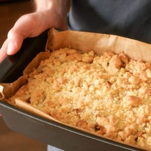 A close up of apple crisp with no oatmeal in a black bowl.