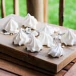 Meringue kisses on a wooden plate.